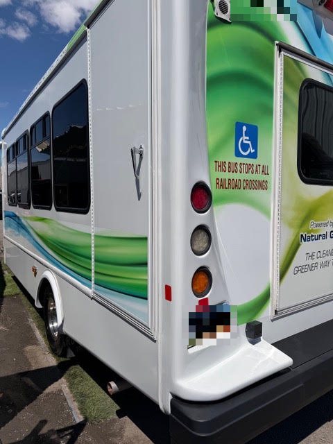 Completed commercial shuttle bus collision repair with restored fiberglass body and paint finish