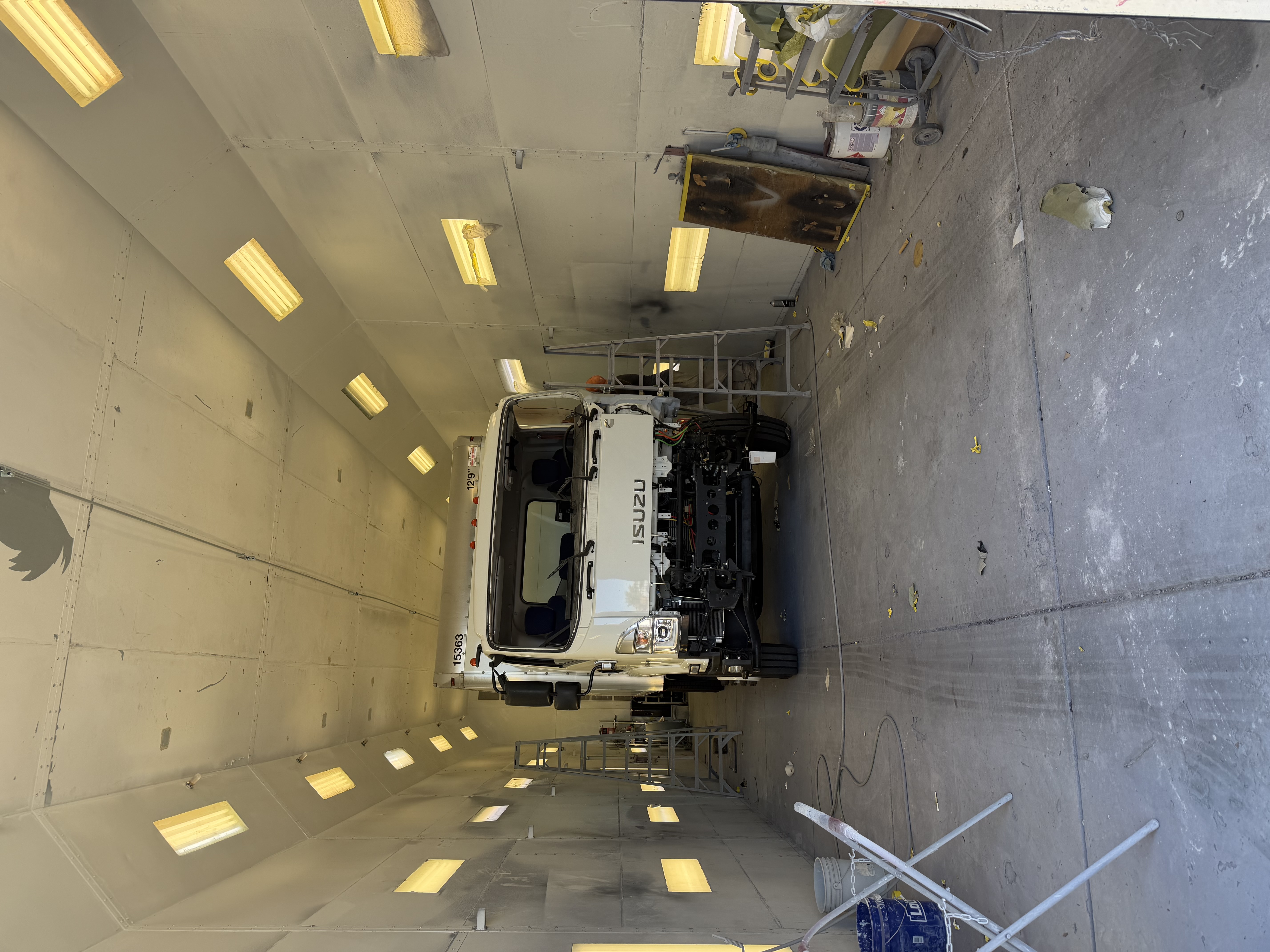 Isuzu commercial box truck inside The Spray Gun’s 67-foot paint booth during refinishing