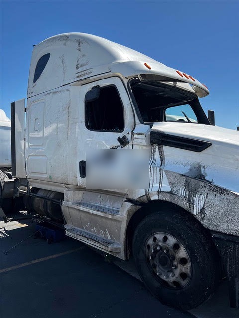 Damage around the passenger door, mirror and sleeper cab of a Freightliner Cascadia after a rollover