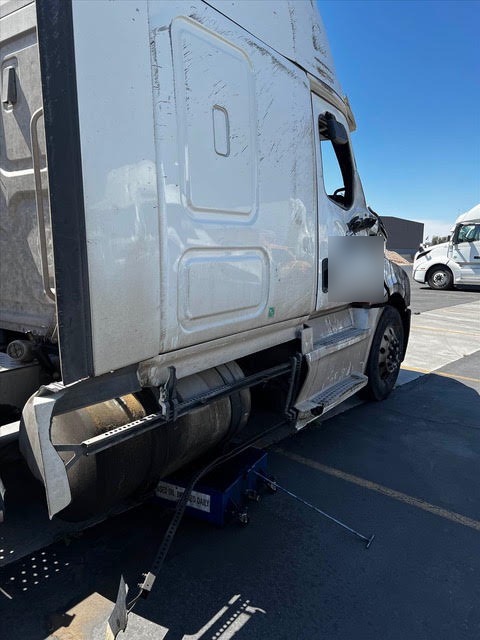 Damaged lower side panels and step area on a rolled Freightliner Cascadia