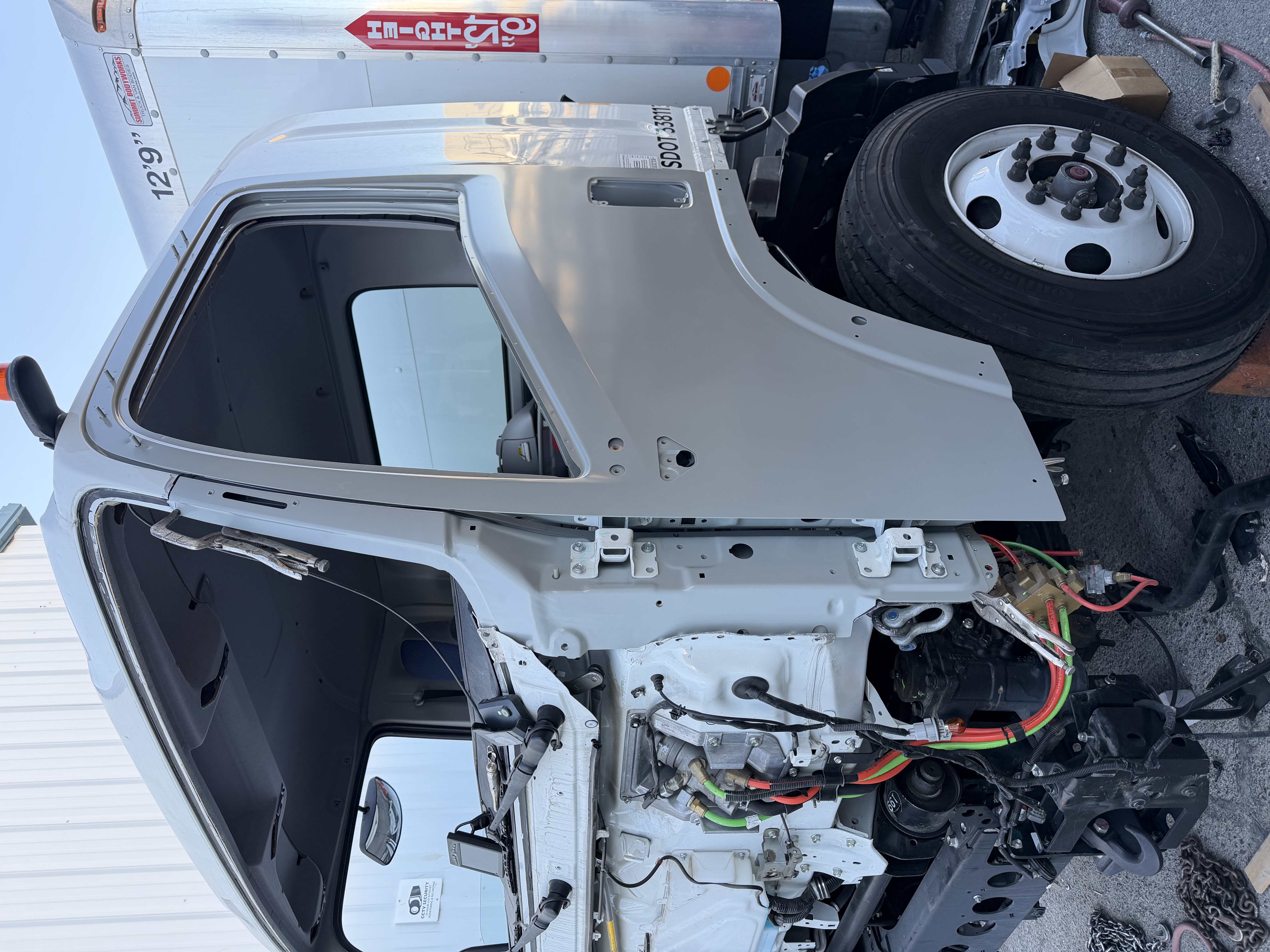 Isuzu FTR cab in primer after A-pillar and hinge pillar replacement during structural repair