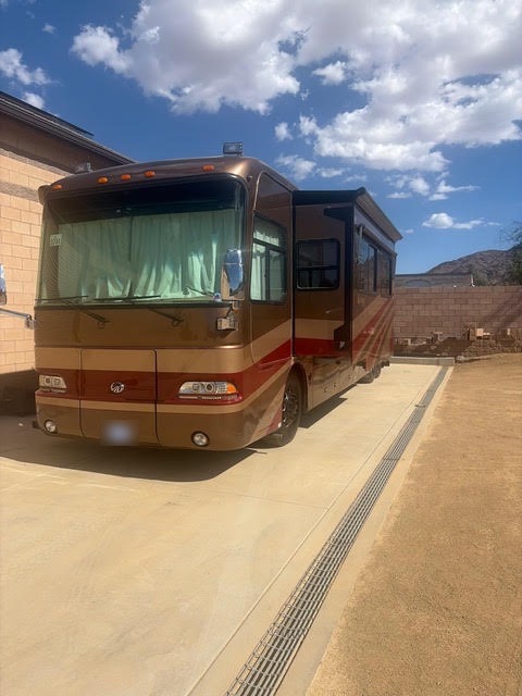 Motorhome with refreshed bronze, cream and burgundy paintwork back at the customer’s home in daylight