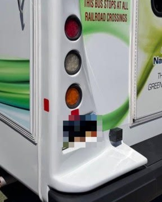 Close-up of the same shuttle bus rear corner after fiberglass reconstruction, with taillights refitted and paint and graphics matched
